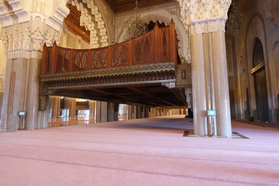 Der prachtvolle Innenraum der Hassan-II.-Moschee beeindruckt mit feinsten Holzschnitzereien, kunstvollen Ornamenten und einer Gebetshalle.