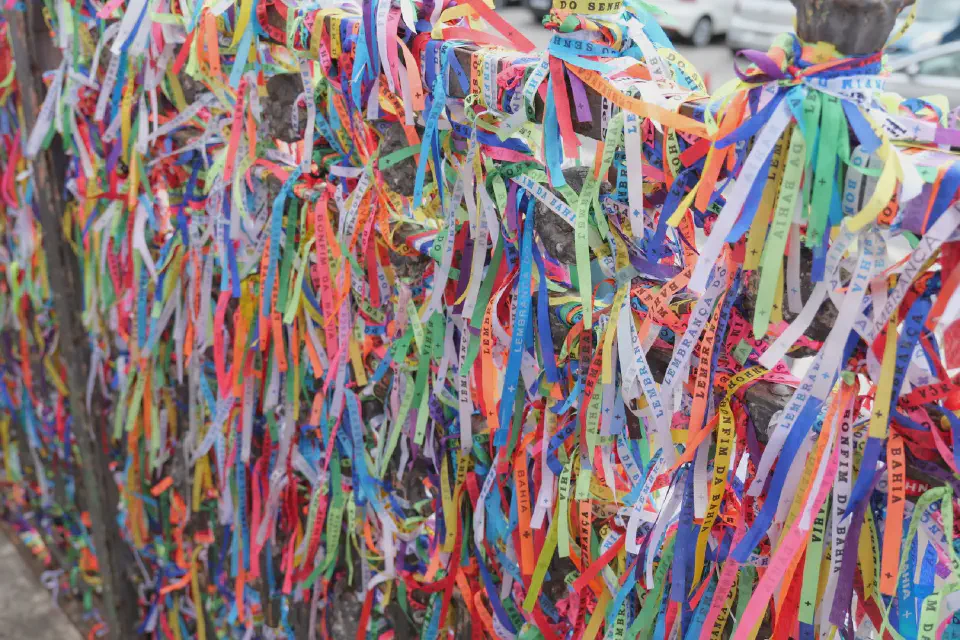Tausende 'Fitas do Bonfim' schmücken die Gitter vor der Kirche – jede Schleife steht für einen Wunsch, ein Gebet oder einen Hoffnungsmoment der Besucher.