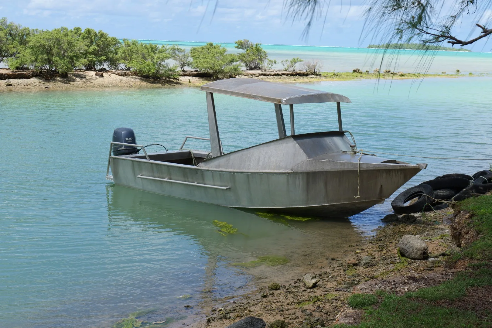 Ein einfaches Aluminiumboot am ruhigen Ufer der Lagune – ein typisches Transportmittel der Inselbewohner.