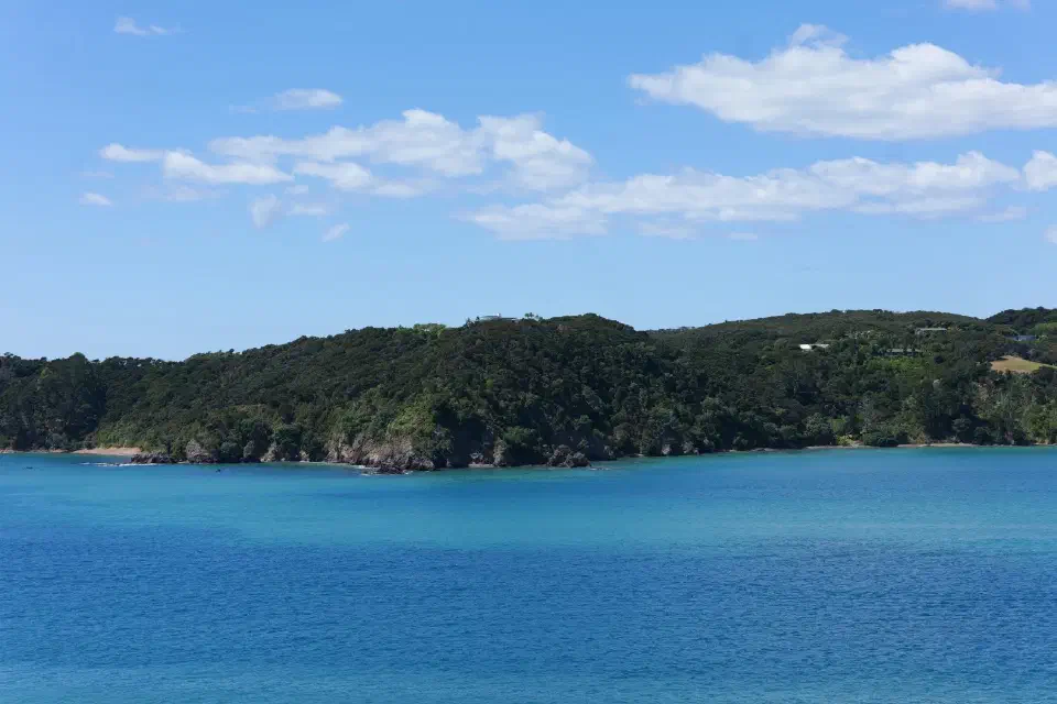 Blick über die türkisfarbenen Gewässer der Bay of Islands, deren ruhige Schönheit einen starken Kontrast zur historischen Bedeutung der Region bildet.