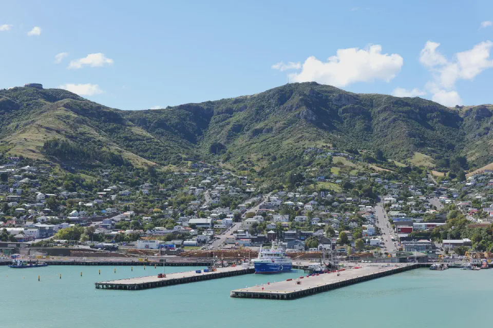 Blick auf den Hafen von Lyttelton, umgeben von steilen Hügeln.
