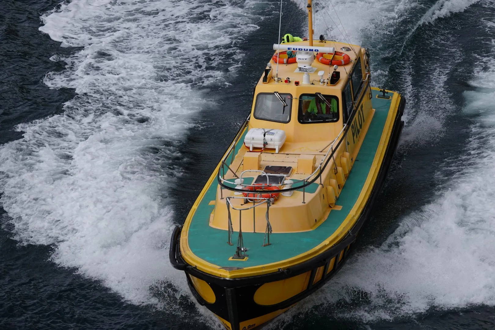 Ein wendiges Arbeits- und Begleitboot zieht seine Spur durch das dunkle Wasser des Milford Sound und unterstreicht die raue, maritime Atmosphäre des Fjords.
