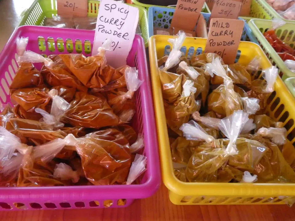 Bunte Körbe mit mildem und scharfem Currypulver auf einem lokalen Markt in Victoria.