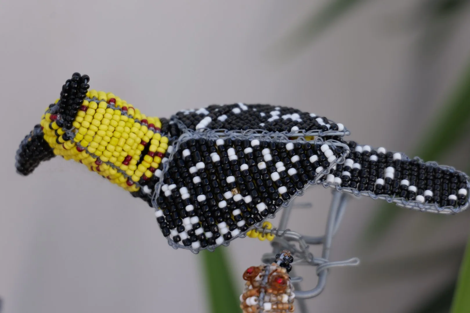 Kunsthandwerk in Form eines farbenfrohen Perlenvogels. Solche handgefertigten Souvenirs spiegeln Kreativität und kulturelle Identität Südafrikas wider.