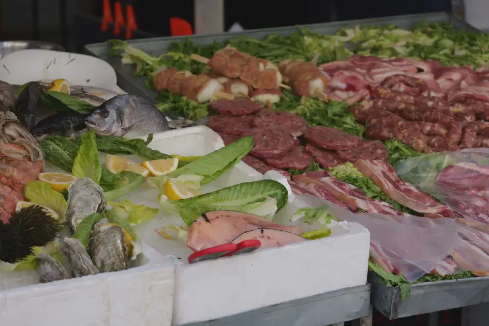 Ein Marktstand in Palermo mit frischem Fisch, Fleisch und regionalen Spezialitäten, ein Spiegel der lebendigen Esskultur Siziliens.