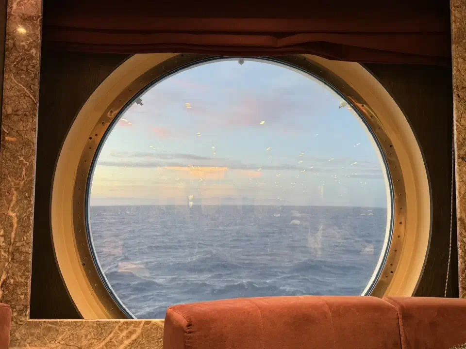 Blick durch ein großes Bullauge auf den offenen Ozean, ein typischer Moment der Ruhe an einem Seetag auf der MSC Magnifica.